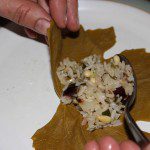 Spooning filling into the grape leaves
