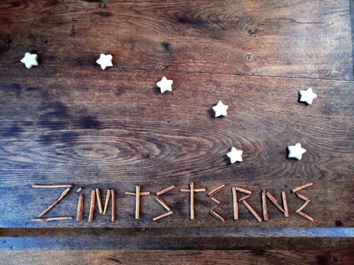 Zimtsterne (cinnamon stars) laid out as the Big Dipper, with the word Zimtsterne spelled out in cinnamon (zimpt) sticks.