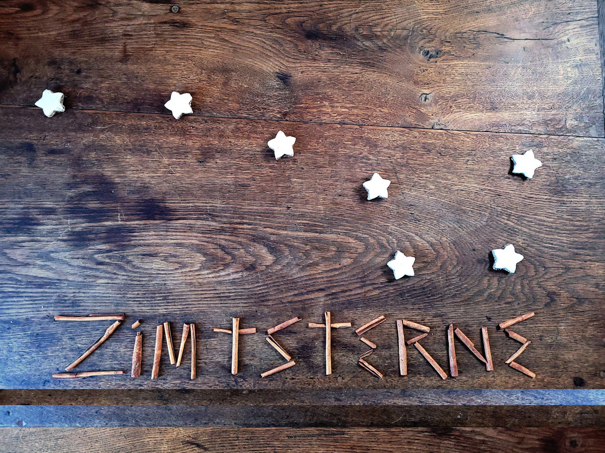 Zimtsterne (cinnamon stars) laid out as the Big Dipper, with the word Zimtsterne spelled out in cinnamon (zimpt) sticks.