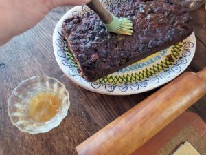 Painting fruitcake with caramel to "glue" marzipan to it