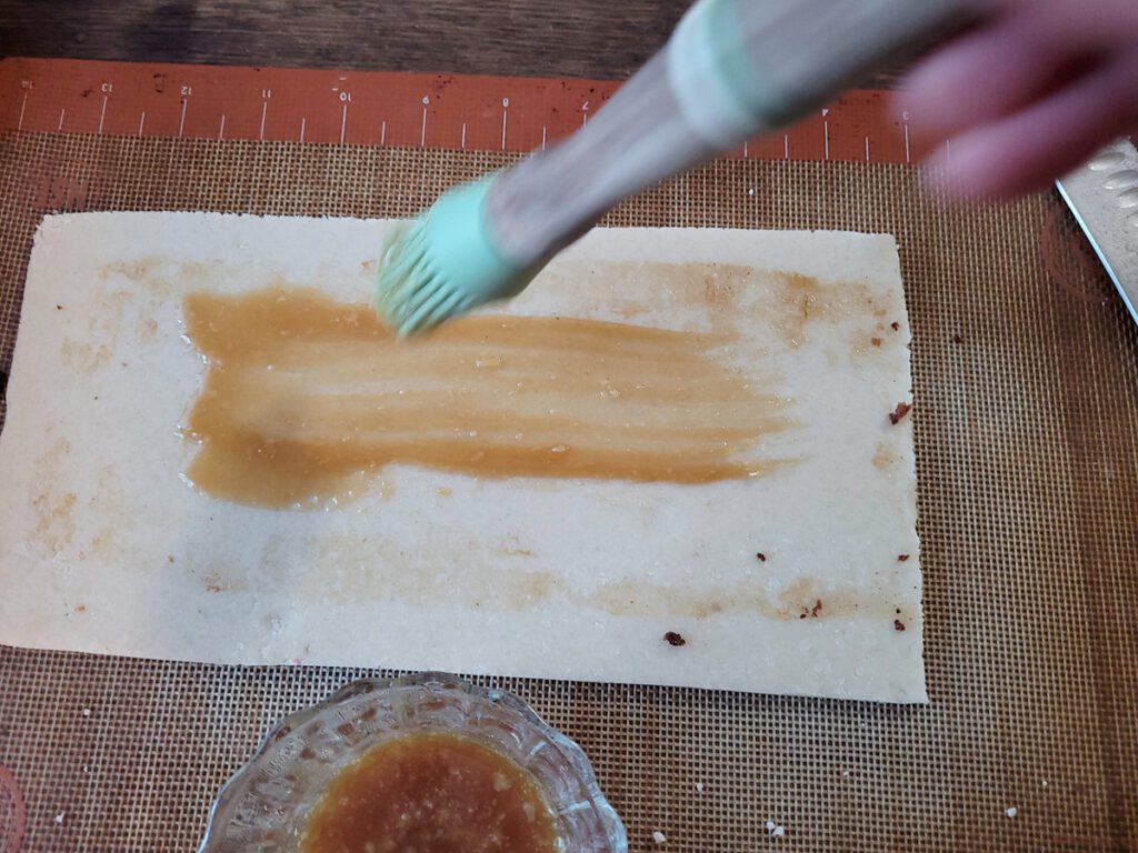 Painting marzipan with caramel to "glue" it to a fruitcake