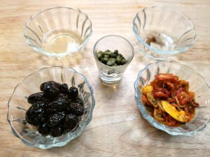 Dried tomatoes, pitted olives, garlic, capers, pits