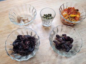 Dried tomatoes, caper brine, olives, garlic clove, and capers