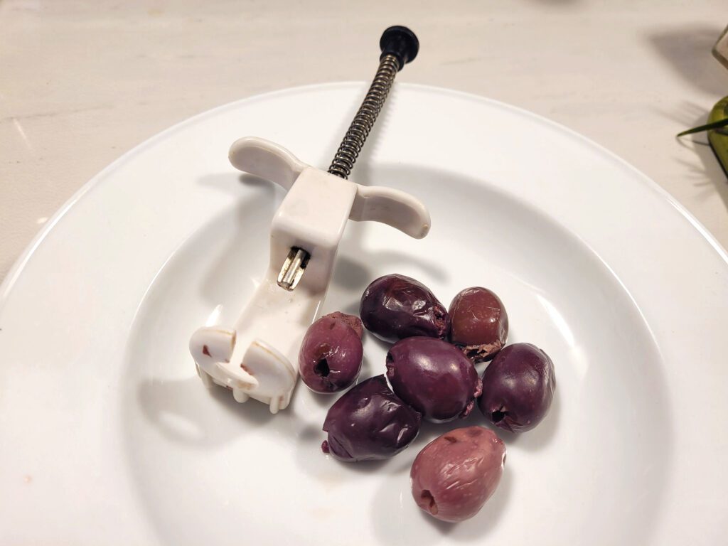 Garlic-stuffed olives with olive pitter, aka cherry pitter