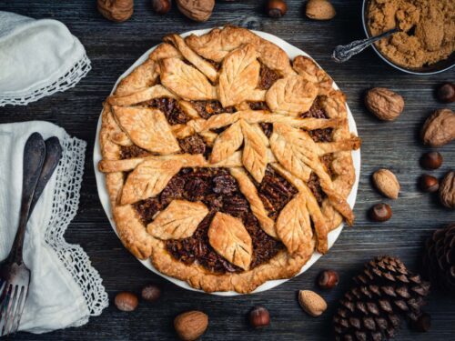 Freshly baked pecan pie with leaves ornament.