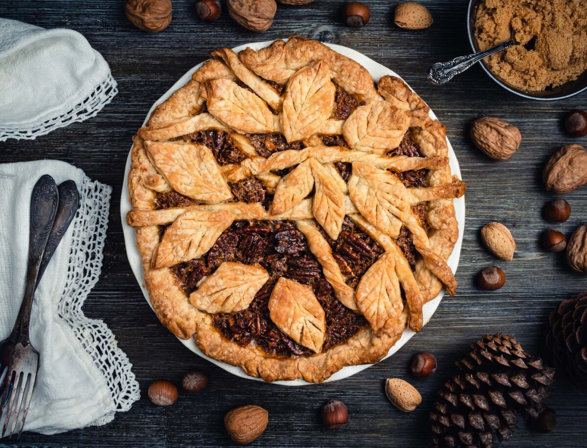 Freshly baked pecan pie with leaves ornament.