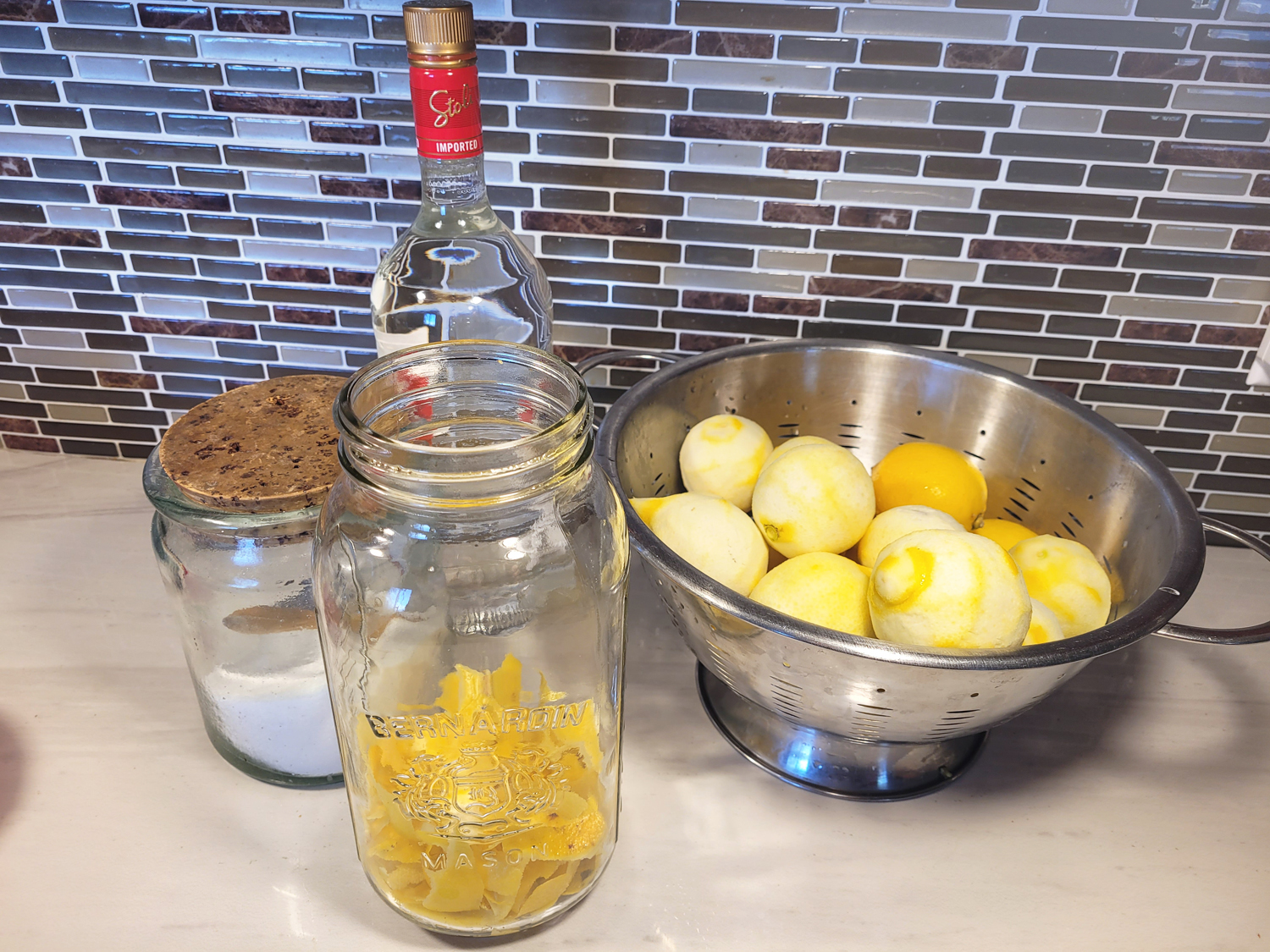 Lemon peels, vodka, sugar, and a jar with a tight-fitting lid, everything needed to make limoncello.