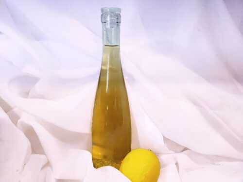 Bottle of limoncello with a lemon on a gauze background